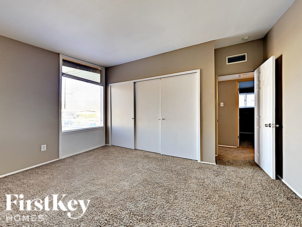 the living room of a house with white doors and a carpeted floor