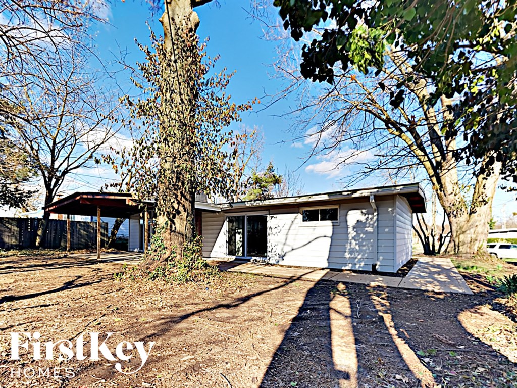 a small white house with a tree in front of it