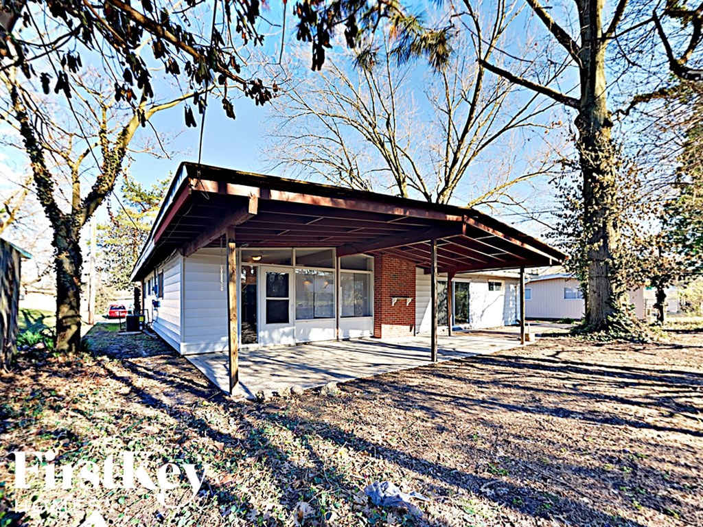 a small house with a covered porch in a yard