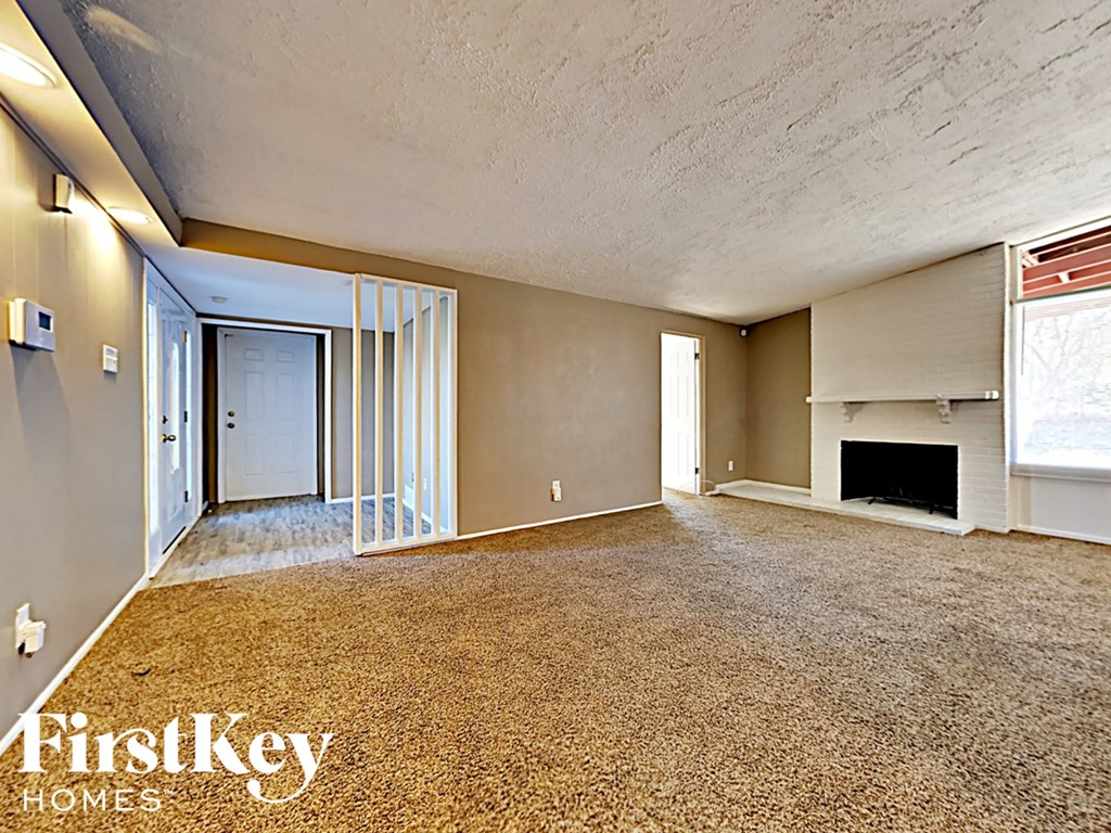 the living room and dining room of an empty house with a fireplace
