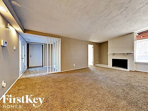 the living room and dining room of an empty house with a fireplace