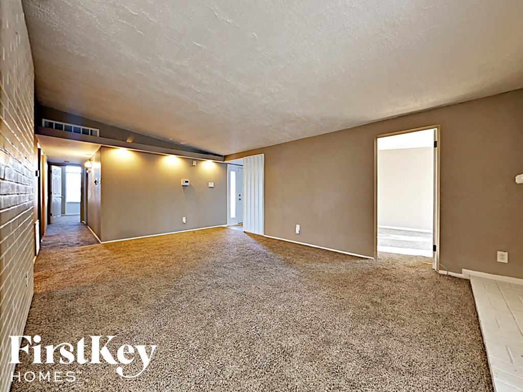 the living room and dining room of a house with a carpeted floor