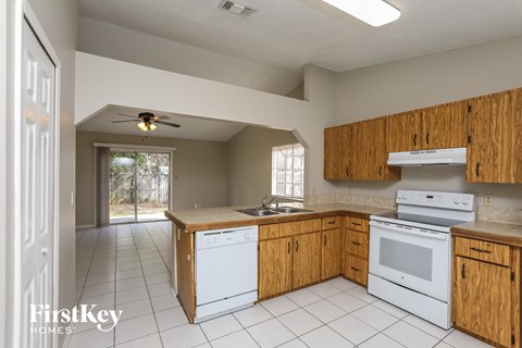 a kitchen with white appliances and wooden cabinets