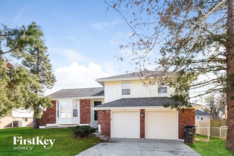 a white and brick house with a driveway