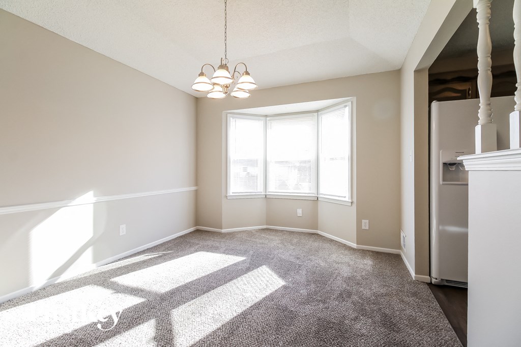 an empty living room with carpet and a large window