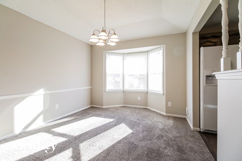 an empty living room with carpet and a large window