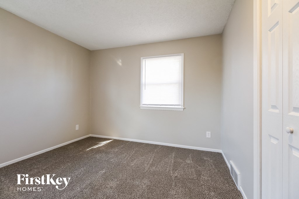 a empty room with carpet and a window