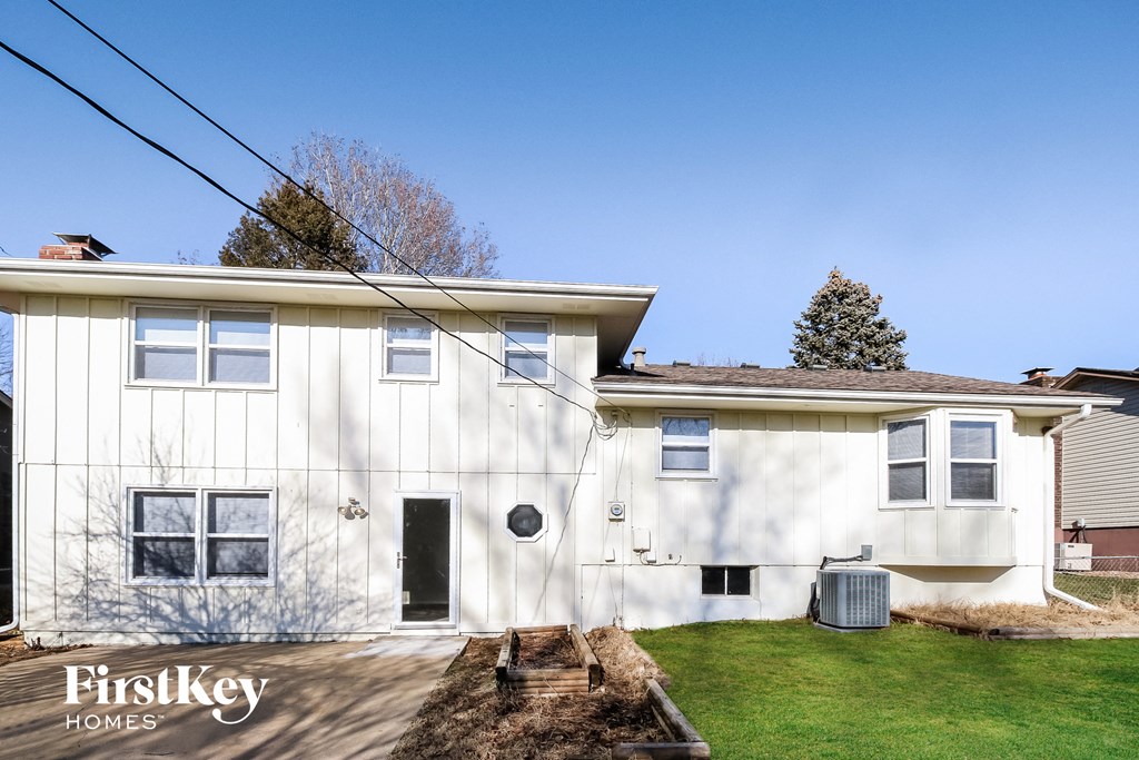 a white house with a green lawn and a blue sky