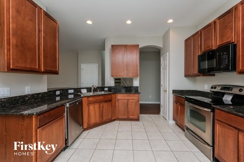 A kitchen with wooden cabinets and black countertops.