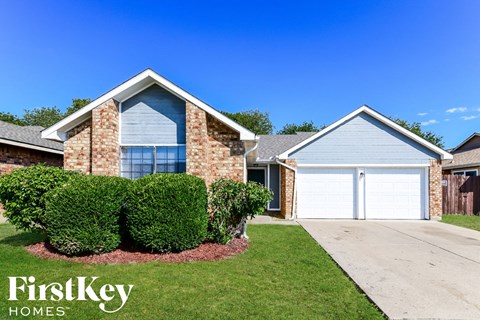 a brick house with a white garage door and a lawn