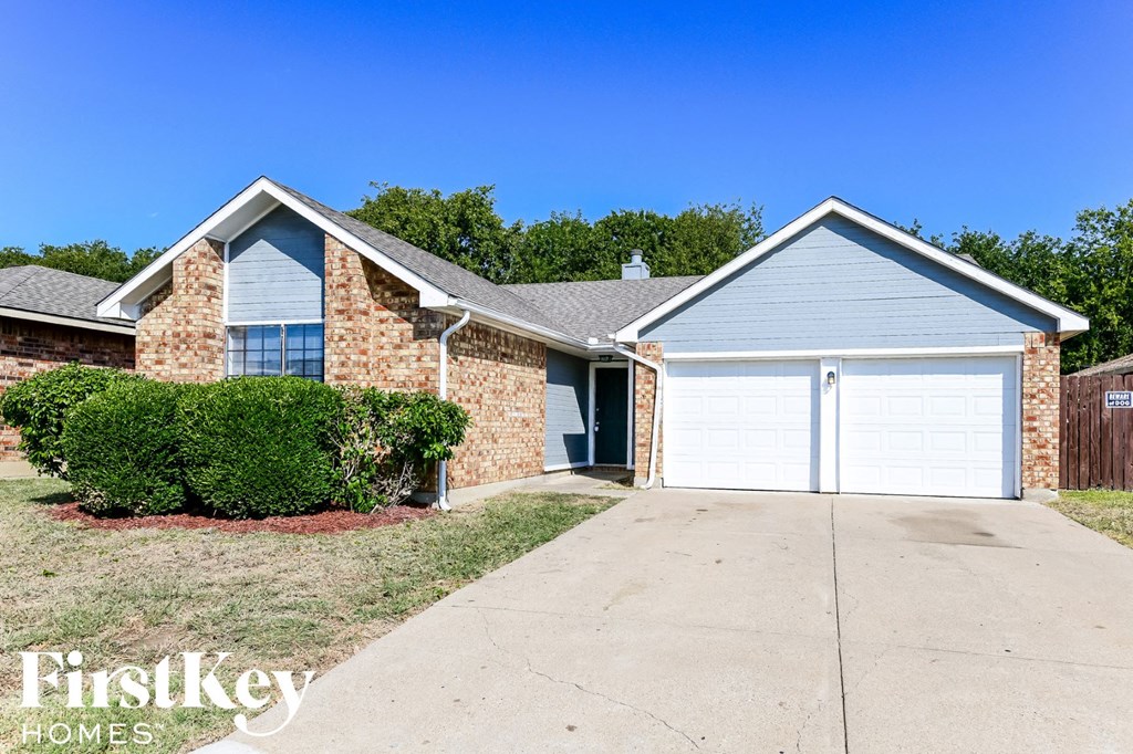a home with a white garage door and a brick house