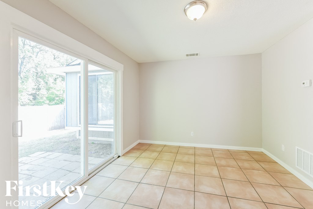 an empty living room with a sliding glass door to a patio