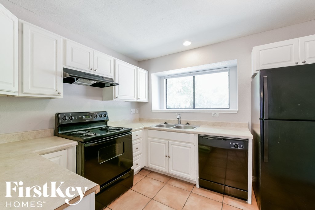 a kitchen with black appliances and white cabinets