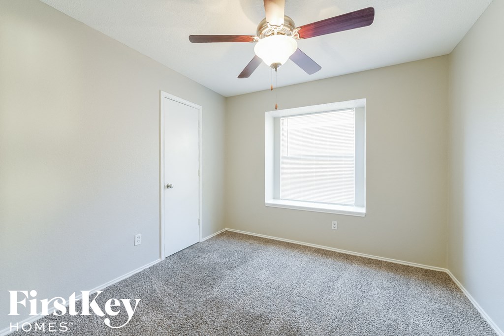 a bedroom with a ceiling fan and a window