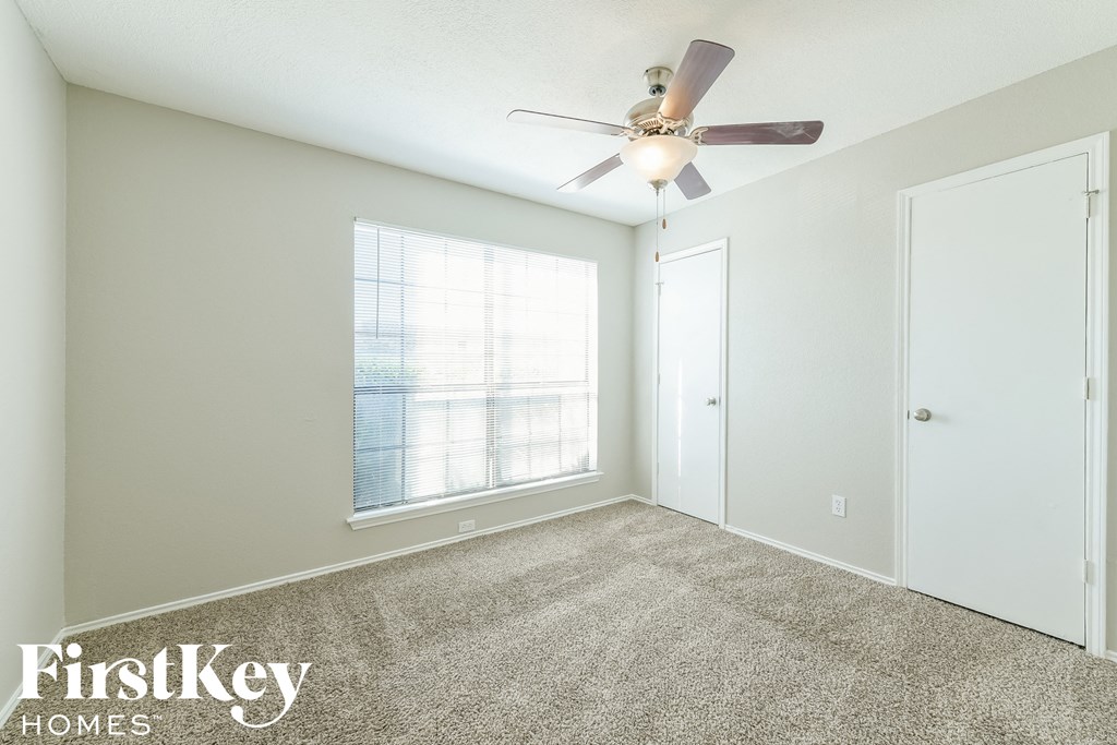 a bedroom with a ceiling fan and a window