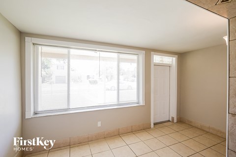 A room with a large window and a tiled floor.
