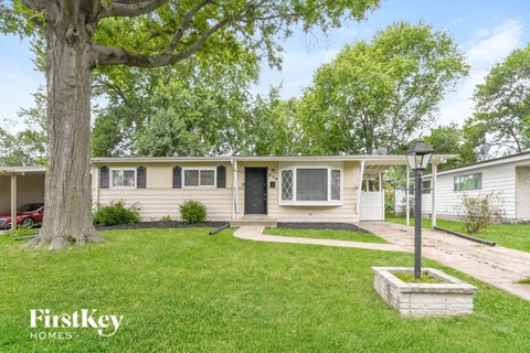 a white house with a yard and a tree