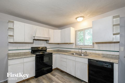 a kitchen with white cabinets and black appliances