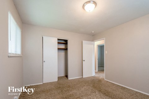 a bedroom with a closet and a door to a hallway