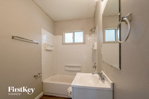 a white bathroom with a sink and a bath tub