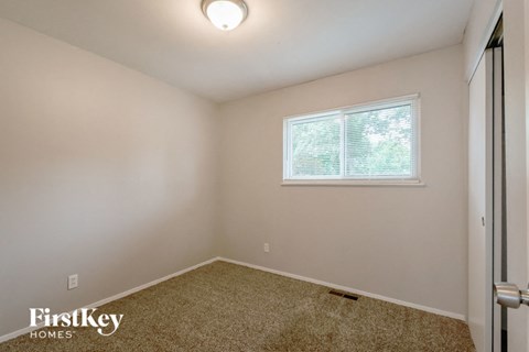 an empty room with a window and a door