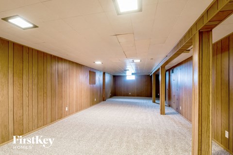 an empty room with wood paneled walls and a carpeted floor