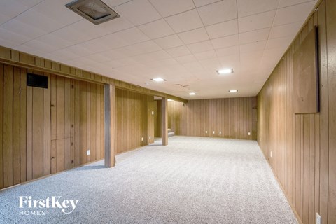 an empty room with wood paneled walls and a carpeted floor