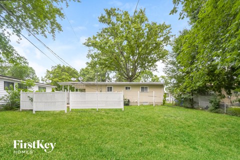 a house with a yard and a white fence