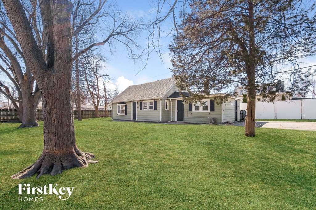 a small house with a yard and two trees