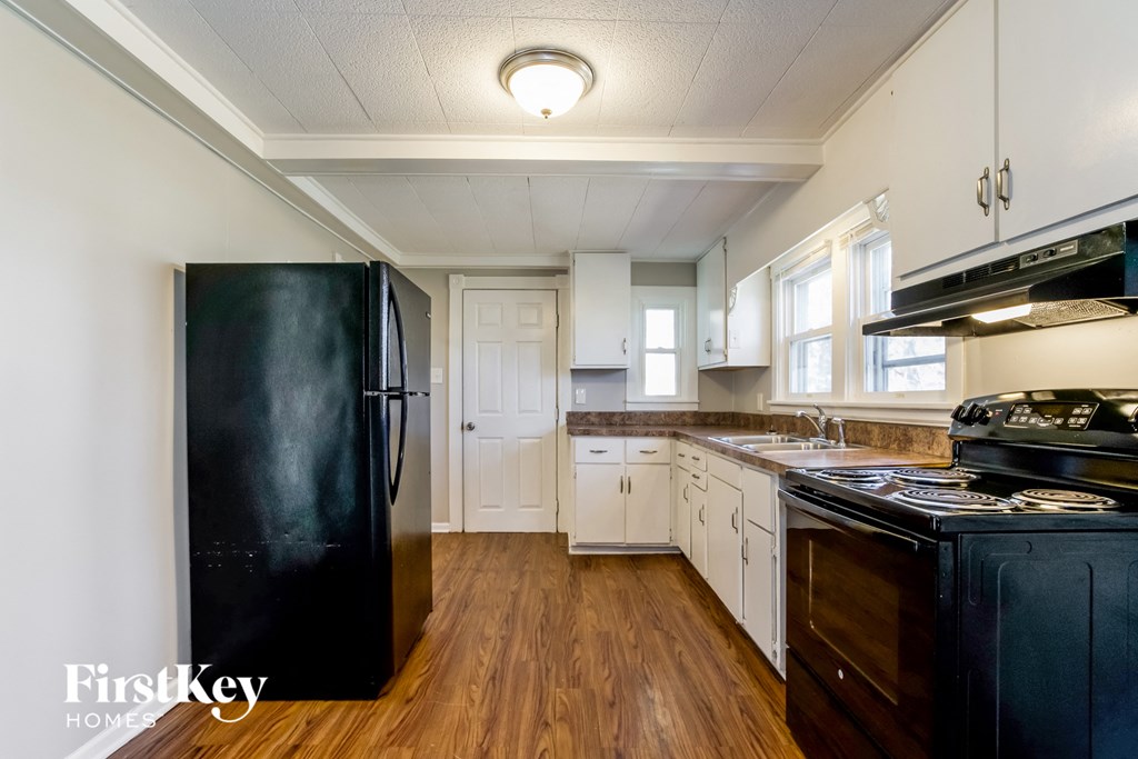 a kitchen with black appliances and white cabinets