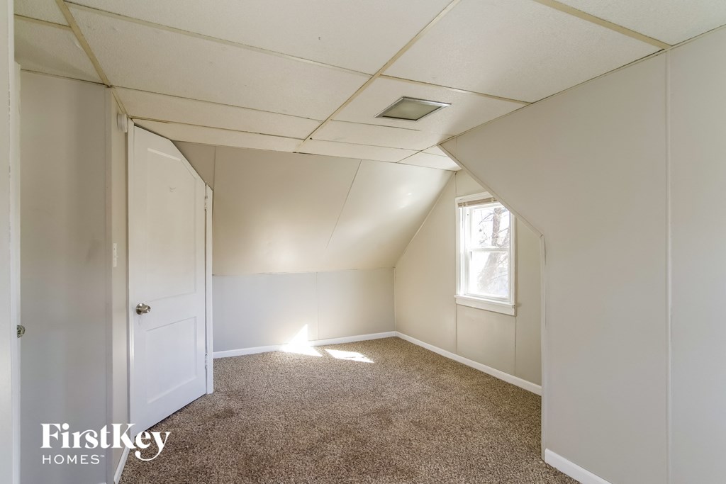 a bedroom with white walls and carpet and a white door