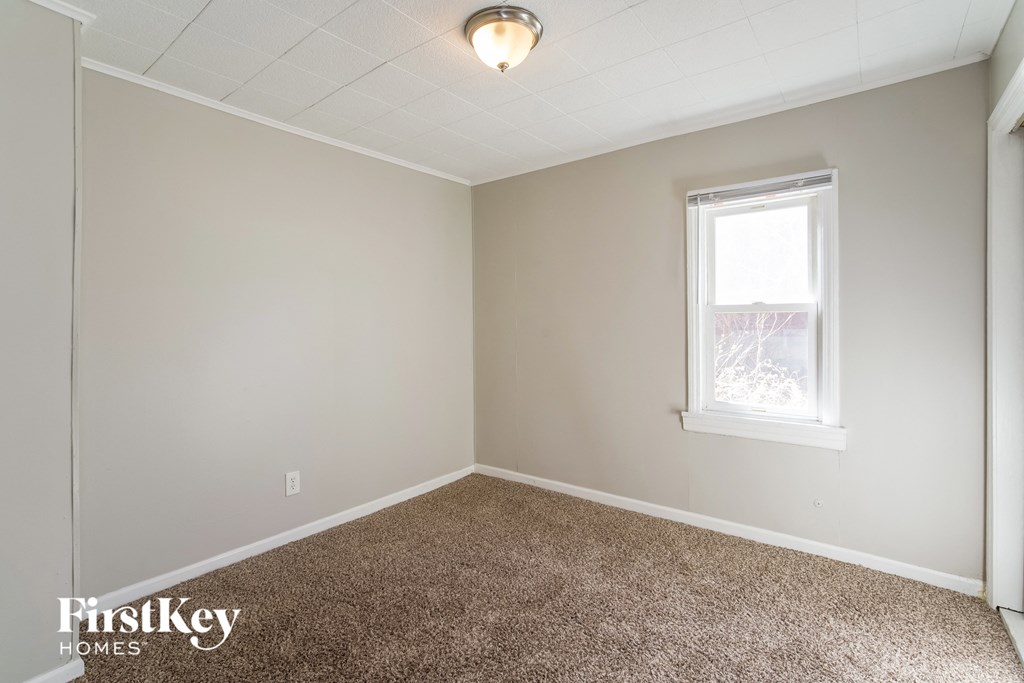 a empty room with carpet and a window