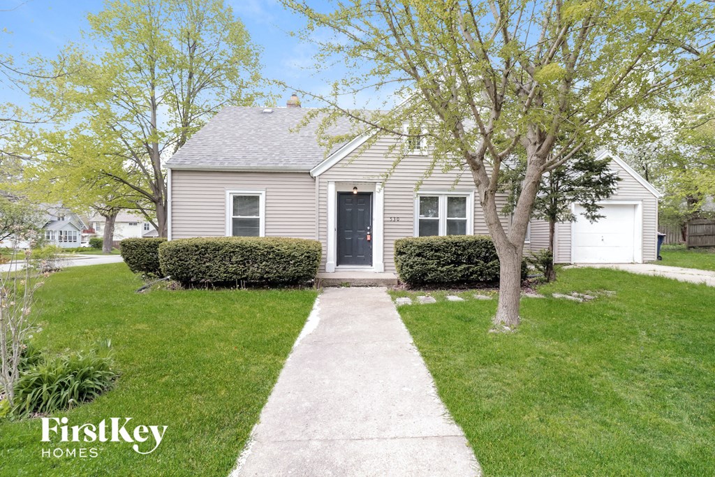 a small white house with a sidewalk in front of it