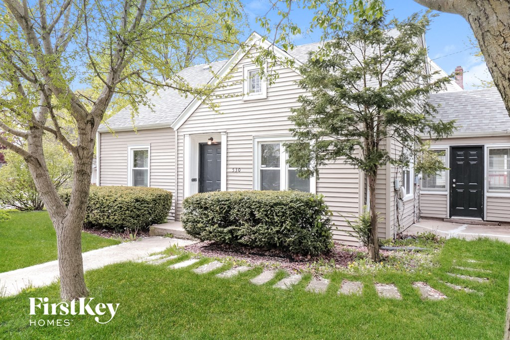 a white house with a sidewalk in front of it