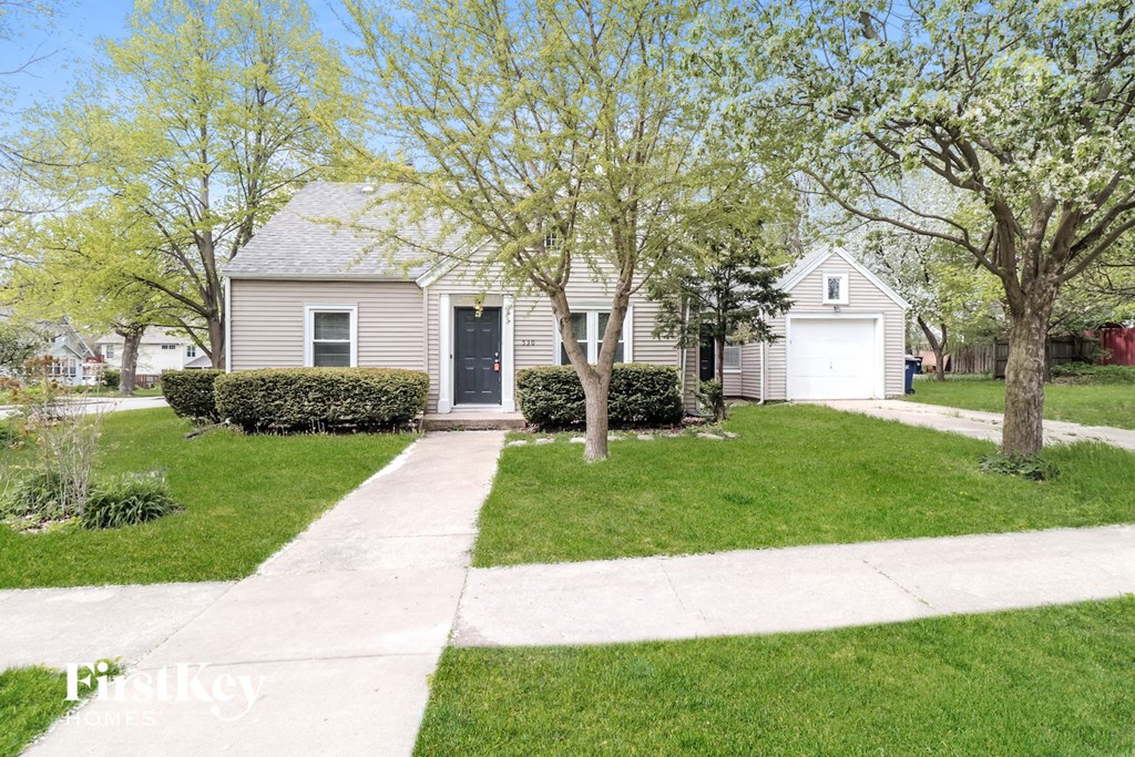 a white house with a lawn and trees in front of it