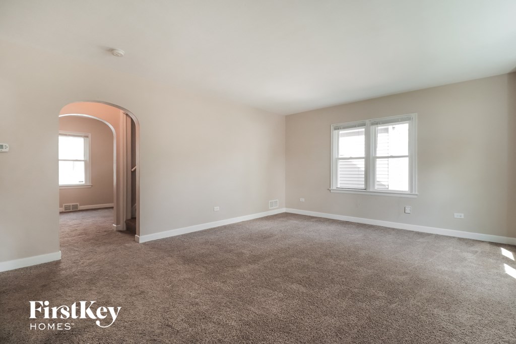 an empty living room with carpet and a window