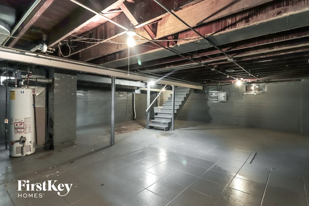 a large empty basement with a staircase in the middle