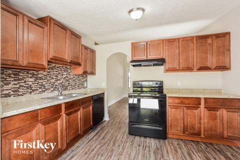 a kitchen with wooden cabinets and a stove and a sink