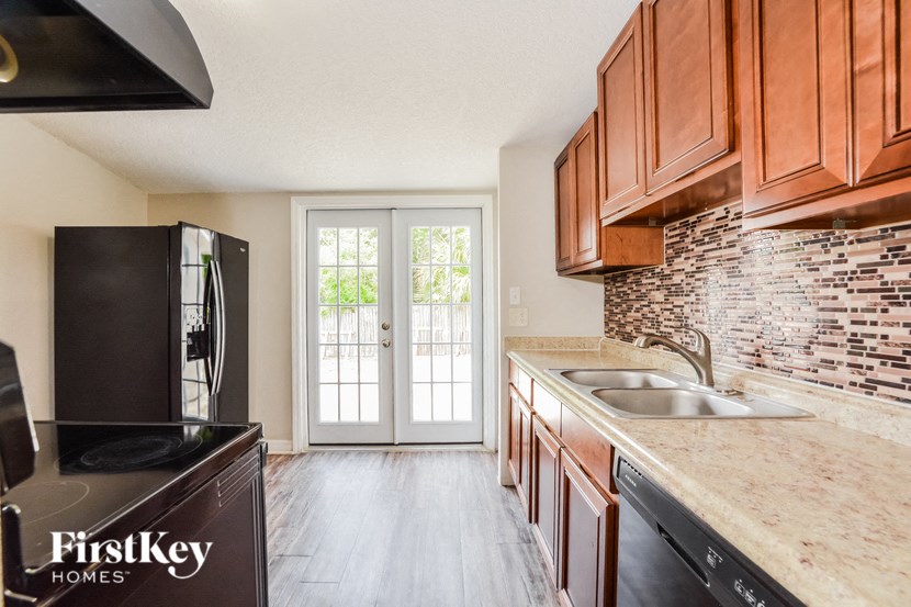 a kitchen with wood cabinets and a door to a patio
