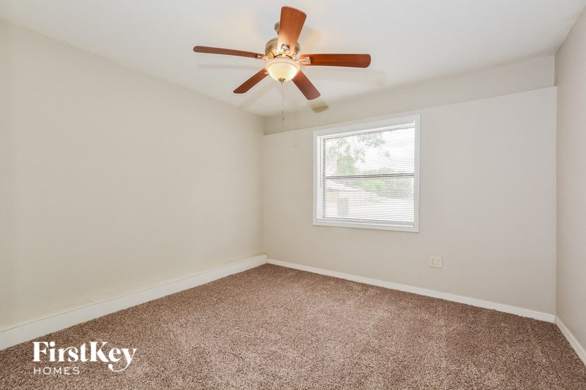 a bedroom with a ceiling fan and a window