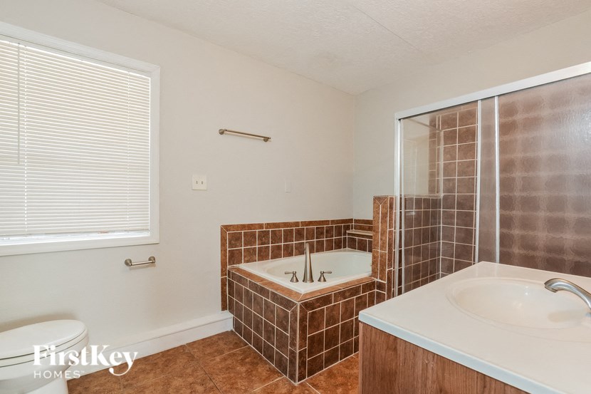 a bathroom with a tub and a sink and a mirror