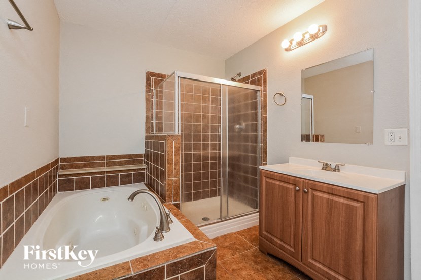 a bathroom with a tub and a shower and a sink