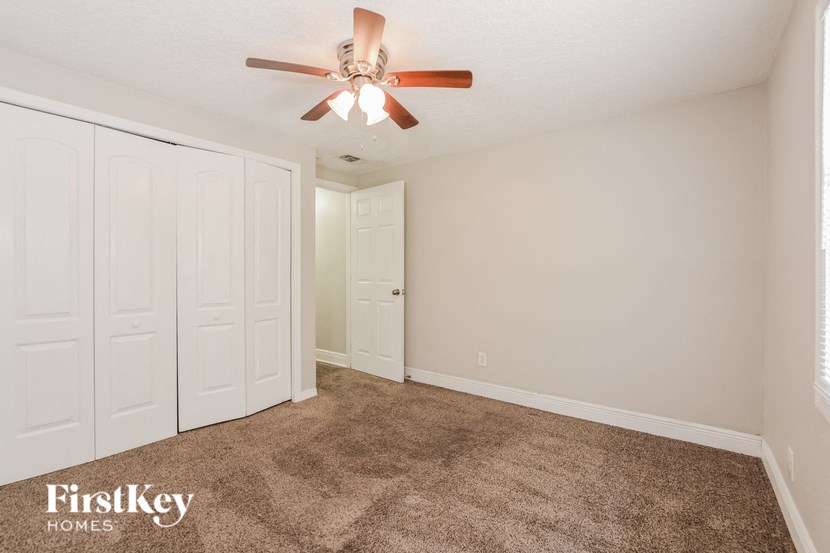 a bedroom with carpet and a ceiling fan