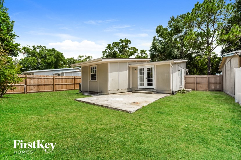a backyard with a shed and a grass yard and a fence