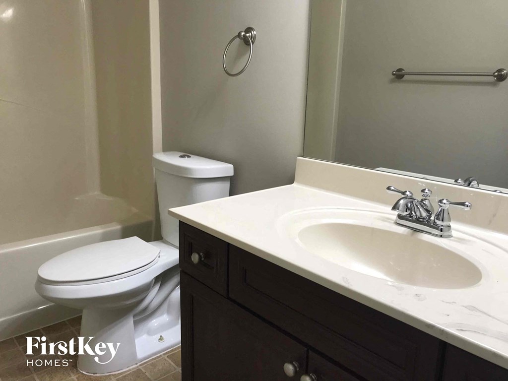 a bathroom with a sink toilet and a mirror