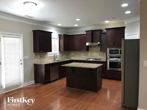 a kitchen with dark cabinets and granite counter tops and stainless steel appliances