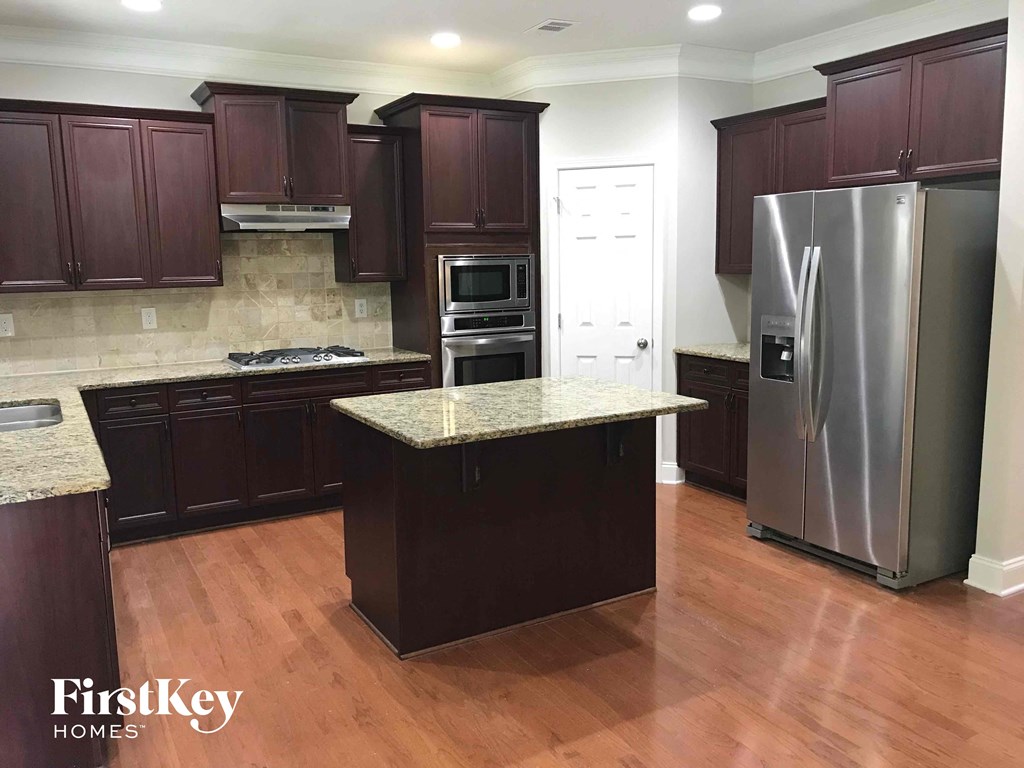 a kitchen with dark cabinets and stainless steel appliances