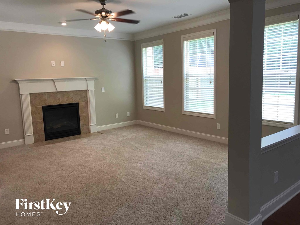 a living room with a fireplace and a ceiling fan
