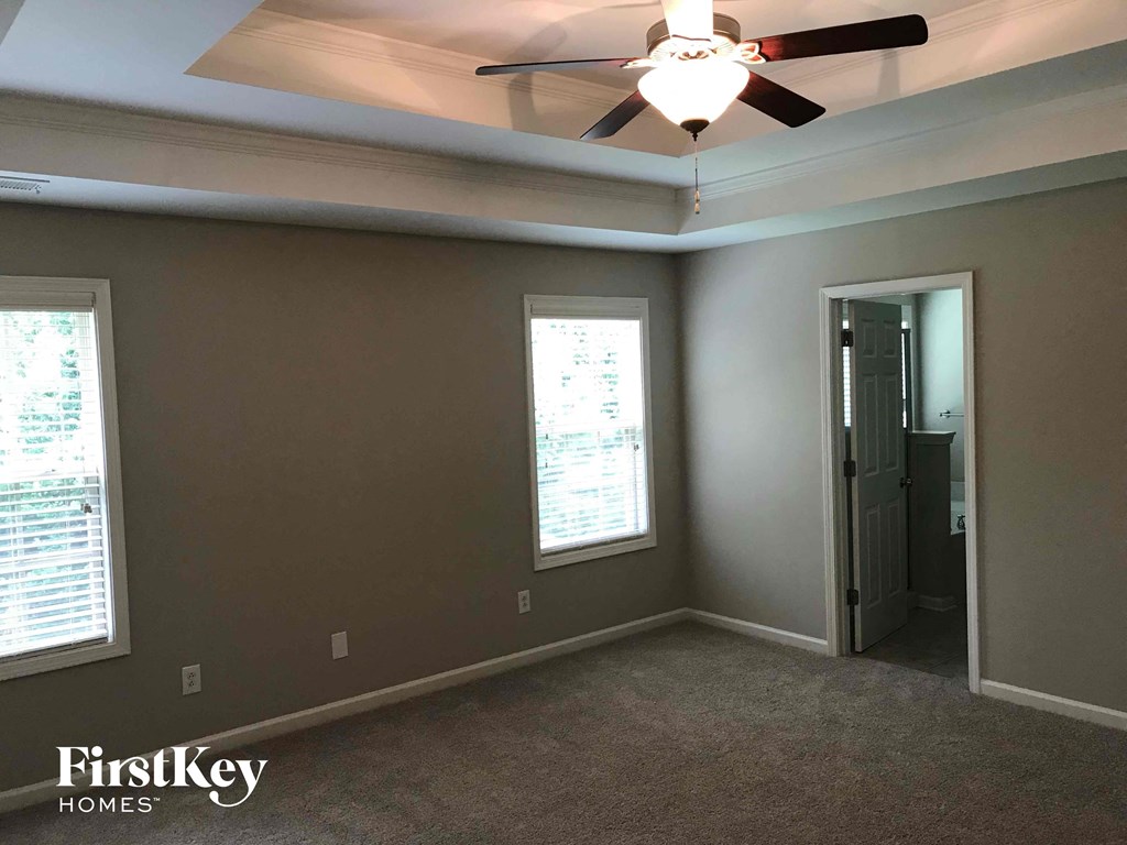a bedroom with a ceiling fan and a door to a closet
