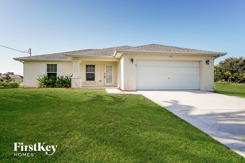 A white house with a garage is for sale by FirstKey Homes.